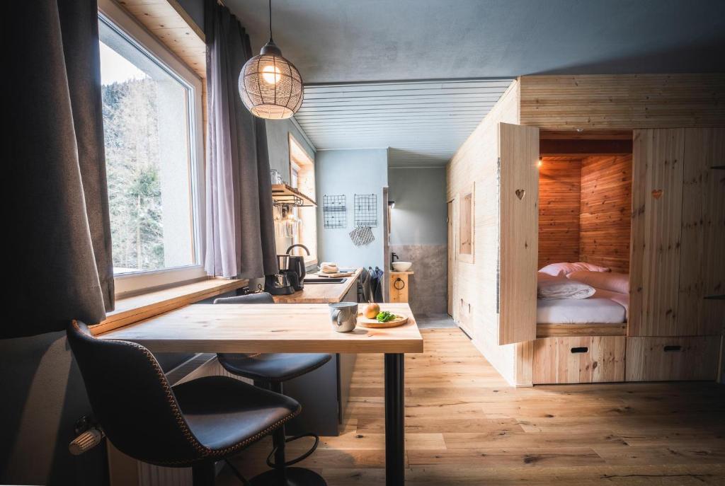 a kitchen with a table and a bed in a room at Tauernlust Outdoor & Relax in Mallnitz