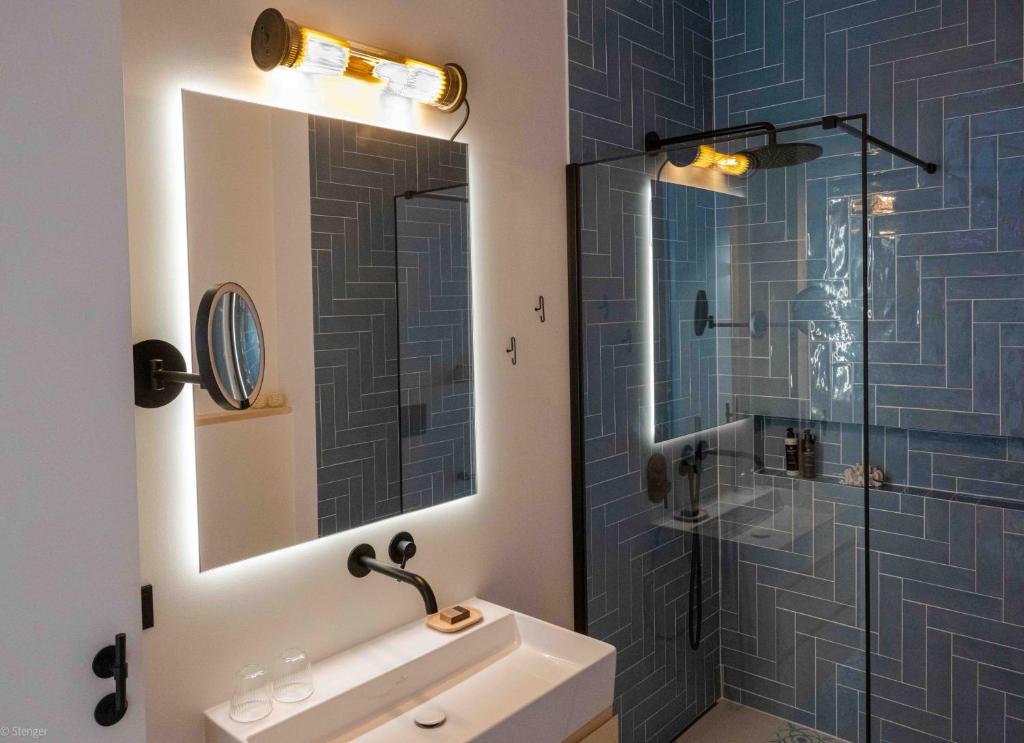 a bathroom with a shower and a sink and a mirror at Mr(s)STiL Design Apartments in Berlin