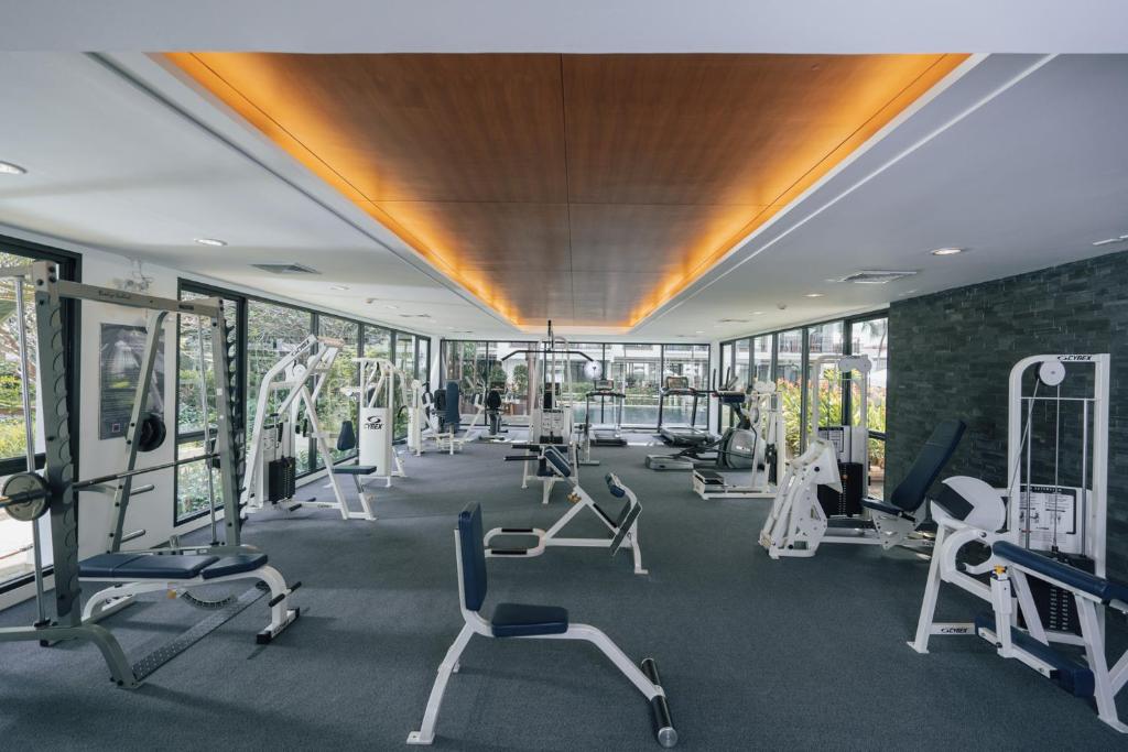 A spacious, window-lined fitness room with cardio and strength equipment.