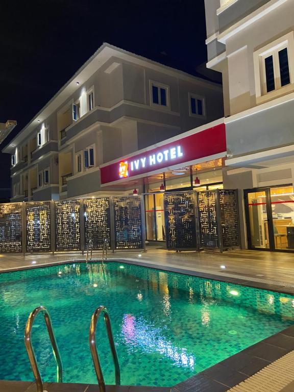 a swimming pool in front of a hotel at night at Ivy Hotel Emerald in Ikeja