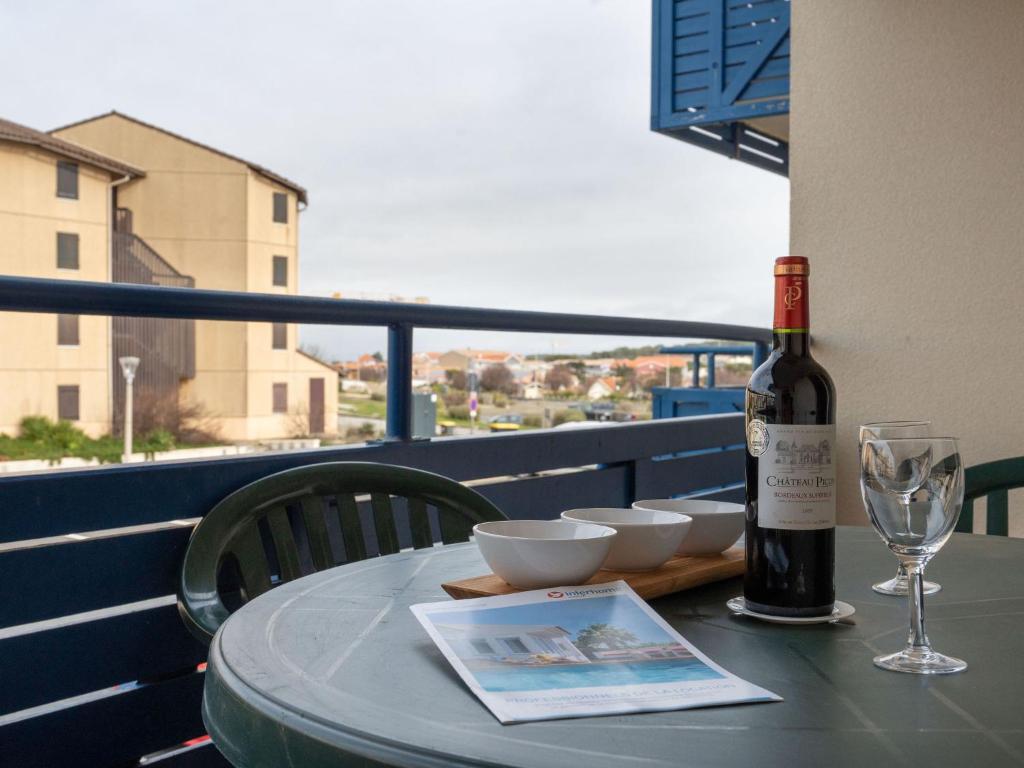 - une bouteille de vin assise sur une table avec un verre dans l'établissement Apartment Bleu Marine-10 by Interhome, à Lacanau-Océan