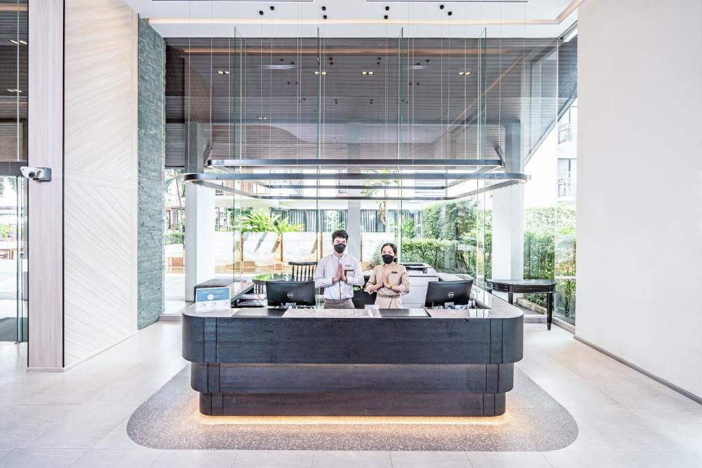 A modern reception desk set in a bright, glass-fronted lobby.