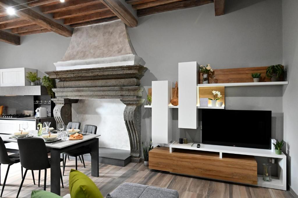 un soggiorno con grande TV e tavolo con sedie di L'Antico Camino - Alloggio Turistico ad Acquapendente