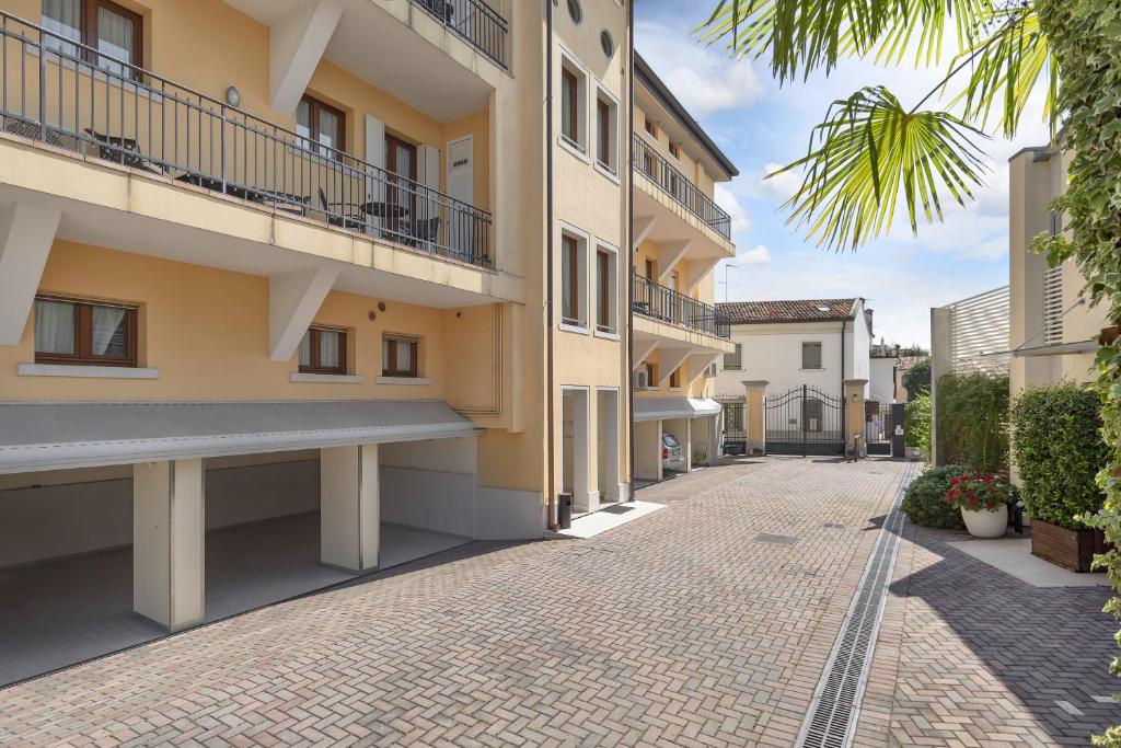 una strada acciottolata di fronte a un edificio di Palazzo Brando - Living Apartments a Treviso
