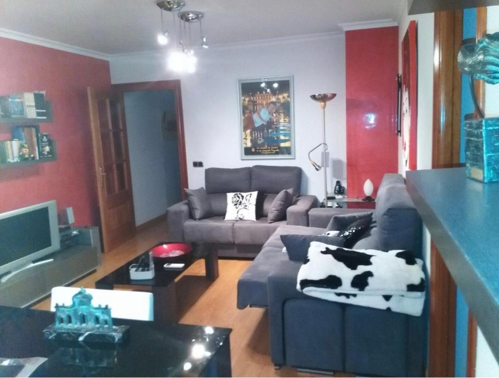 een woonkamer met een koeienkussen op een bank bij Buenos Aires apartamento in Guadix