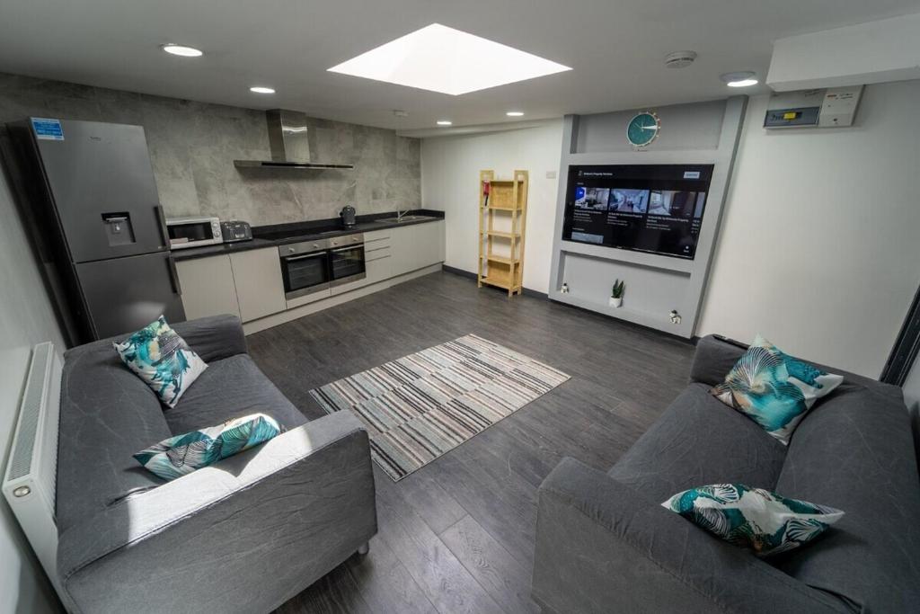 a living room with two couches and a kitchen at STAY SA Equipped Studios 10 mins from City centre and next to UOB! in Birmingham