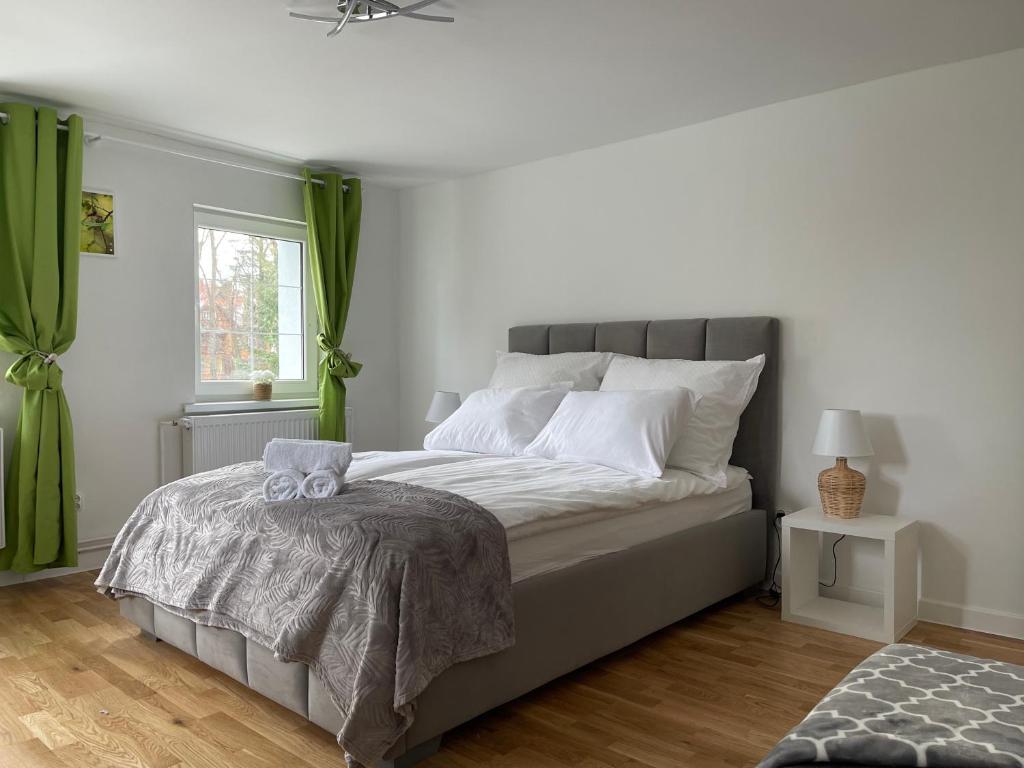 sypialnia z dużym łóżkiem z zielonymi zasłonami w obiekcie Domek Przy Termach w Jeleniej Górze
