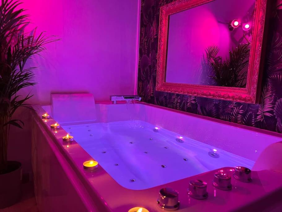 a purple bathroom with a tub with lights in it at La balnéo du Couvent in Dijon