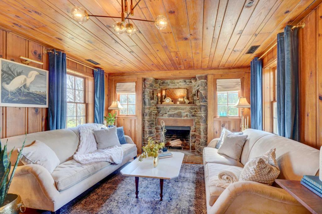 una sala de estar con sofás y una chimenea de piedra. en Historic Tennessee Vacation Rental on Homestead, en Crossville