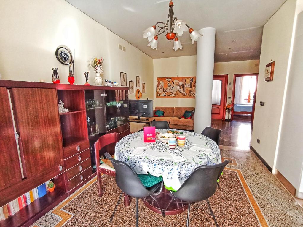 uma sala de jantar com uma mesa e algumas cadeiras em La casa sul mare-Savona em Savona