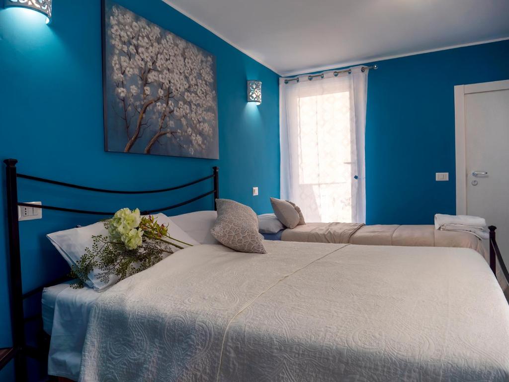 ein Schlafzimmer mit blauen Wänden und einem Bett mit Blumen darauf in der Unterkunft Flower House in Santo Stefano di Camastra