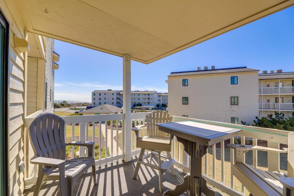 a patio with a table and chairs on a balcony at Emerald Isle Vacation Rental with Resort Pool! in Emerald Isle
