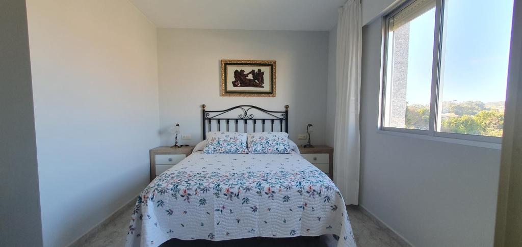 Ce lit se trouve dans une chambre blanche dotée d'une fenêtre. dans l'établissement Alojamiento en Portonovo Playa, à Sanxenxo