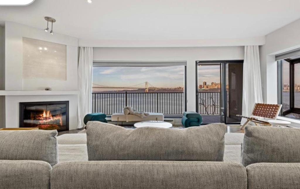 a living room with a couch and a fireplace at Panorama Hudson River view in Edgewater