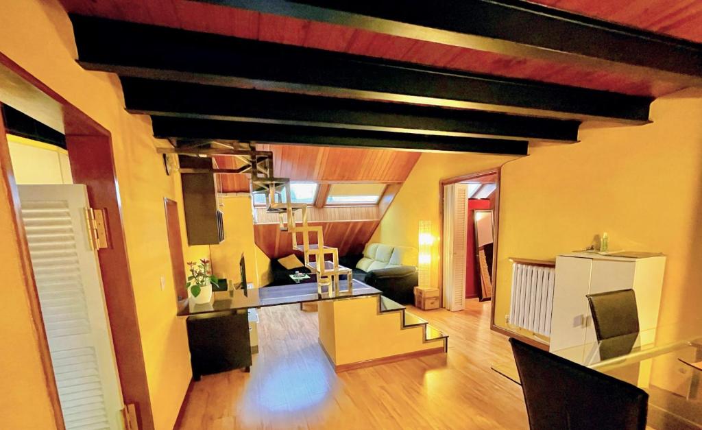 uma sala de estar com um sofá e uma escada num quarto em Buhardilla original em León