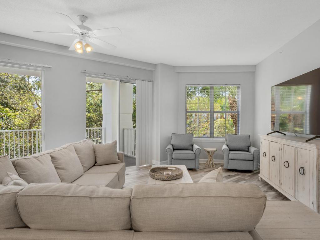 a white living room with a couch and a tv at Blue Mountain Beach Condominium 102 by Newman-Dailey in Santa Rosa Beach
