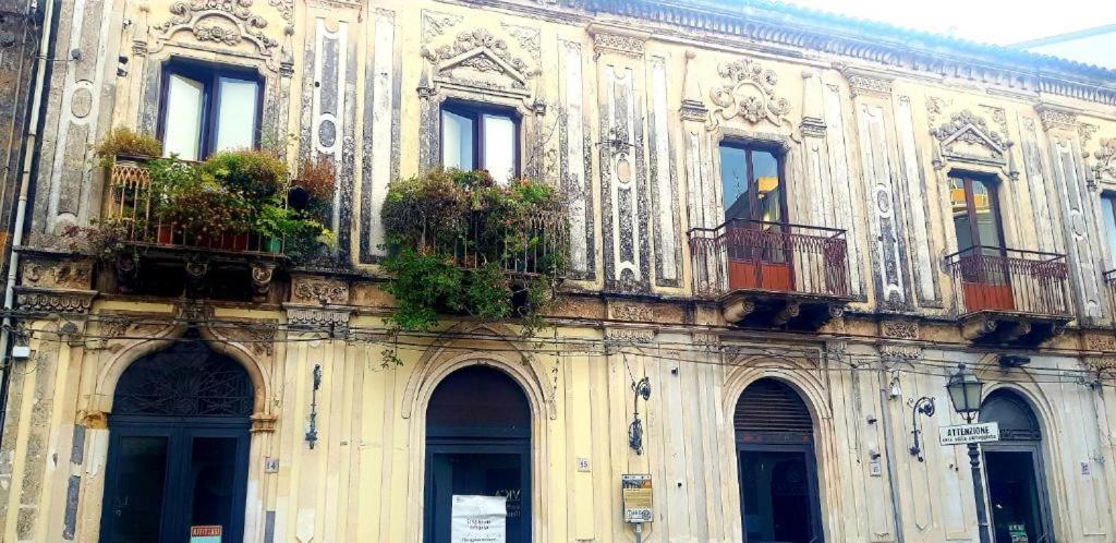Un edificio con balcones y plantas en macetas. en Gli appartamenti del Casino dei Civili, en Trecastagni