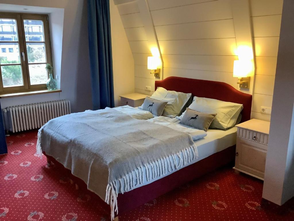 ein Schlafzimmer mit einem großen Bett und einem Fenster in der Unterkunft Strandhotel Berg in Berg am Starnberger See