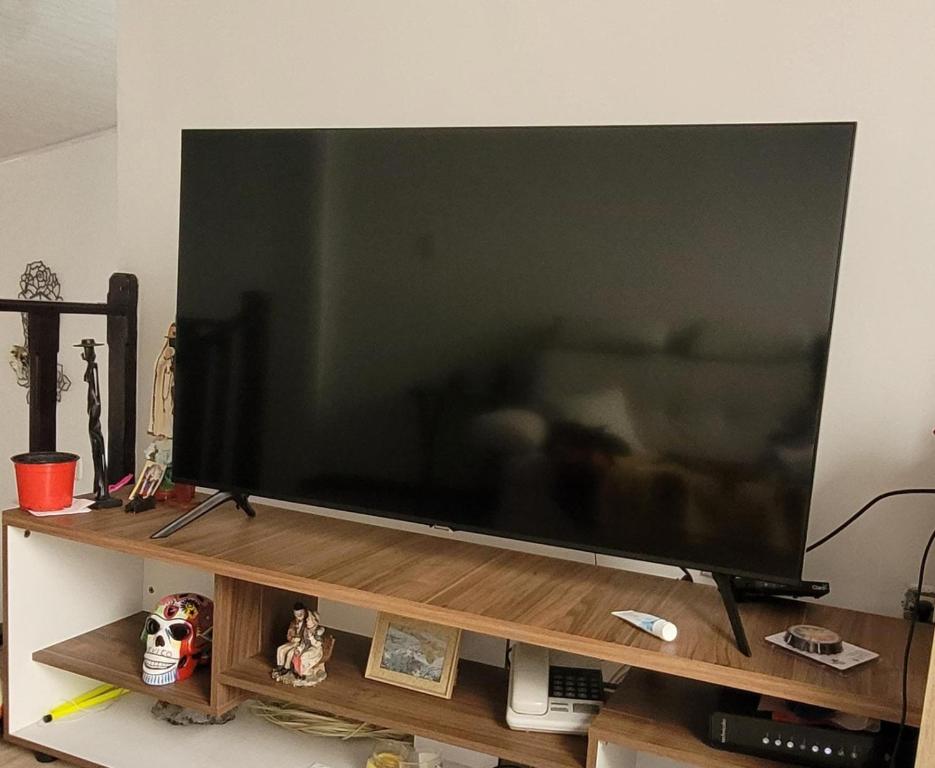 a large flat screen television on a wooden stand at Habitación en Casa familiar - Excelente barrio Zipaquira in Zipaquirá