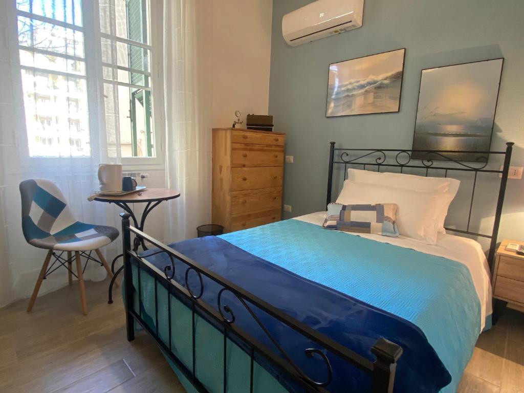 sypialnia z łóżkiem, krzesłem i biurkiem w obiekcie Iola Rooms - Q9416 w Cagliari