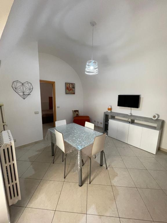a dining room with a table and chairs and a tv at La casetta in Santeramo in Colle