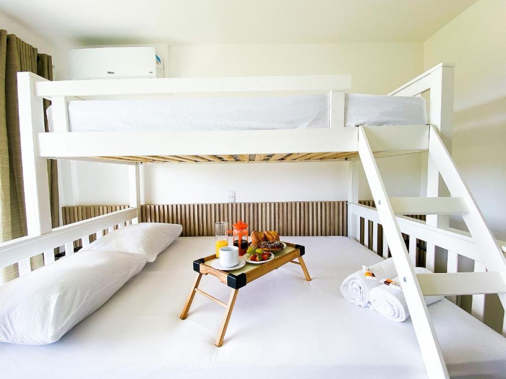ein Etagenbett mit einem Tisch in einem Zimmer in der Unterkunft Vista mar incrível pertinho do Beach Park in Aquiraz