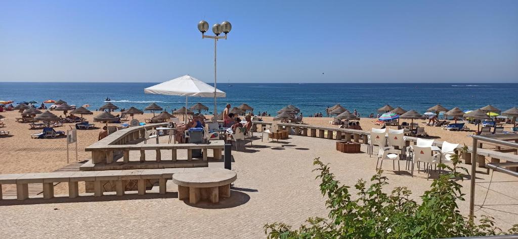 - une plage avec des chaises et des parasols et l'océan dans l'établissement Albufeira Beach - Tranquilidade junto à praia e ao centro!, à Albufeira