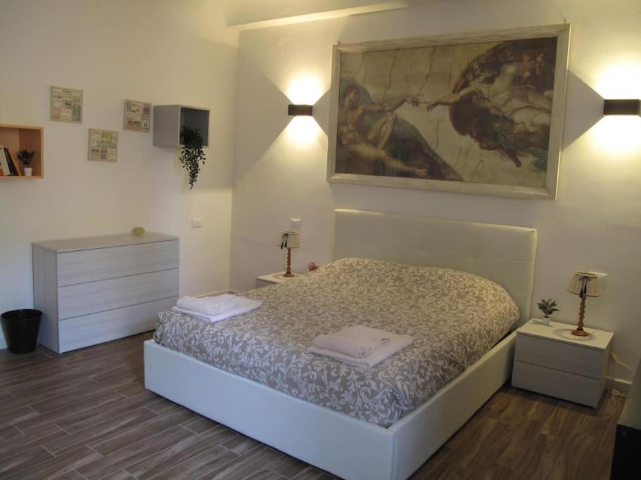 フィレンツェにあるAppartamento Santa Croceのベッドルーム1室(ベッド1台付)が備わります。壁には絵画が飾られています。