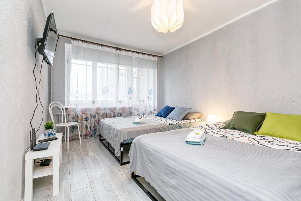 a bedroom with two beds and a window at Dubnas iela - 6 can stay in Rīga