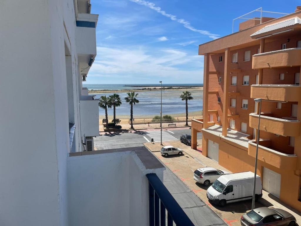 a view of the beach from the balcony of a building at Piso Isla Cristina Punta del Caimán in Isla Cristina