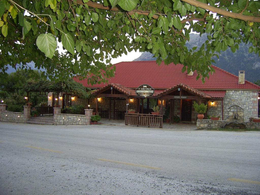 a building with a red roof on a street at Guesthouse Kastania Korakis in Kastanéa