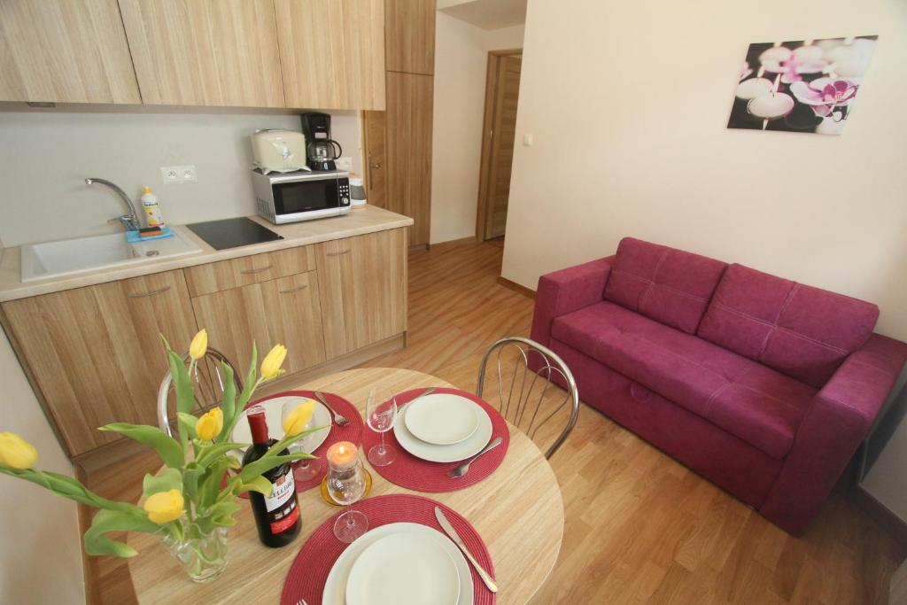 - un salon avec une table et un canapé violet dans l'établissement Apartments Sobieski&Soplica, à Cracovie