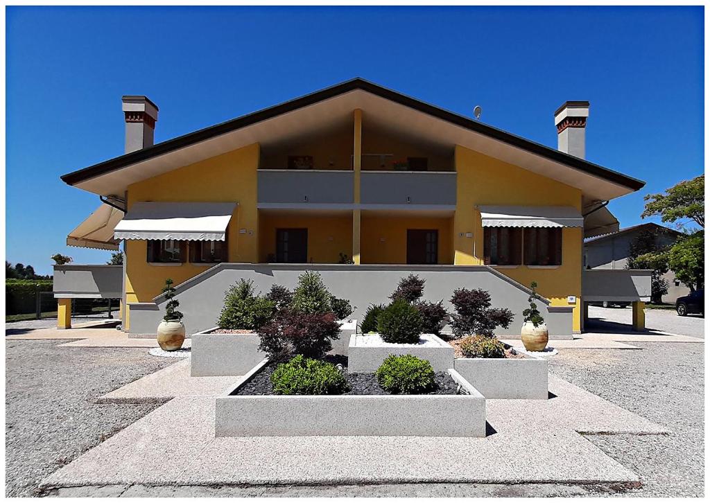 un bâtiment jaune avec des plantes devant lui dans l'établissement TERRE AGRICOLAE B&B, à Marina