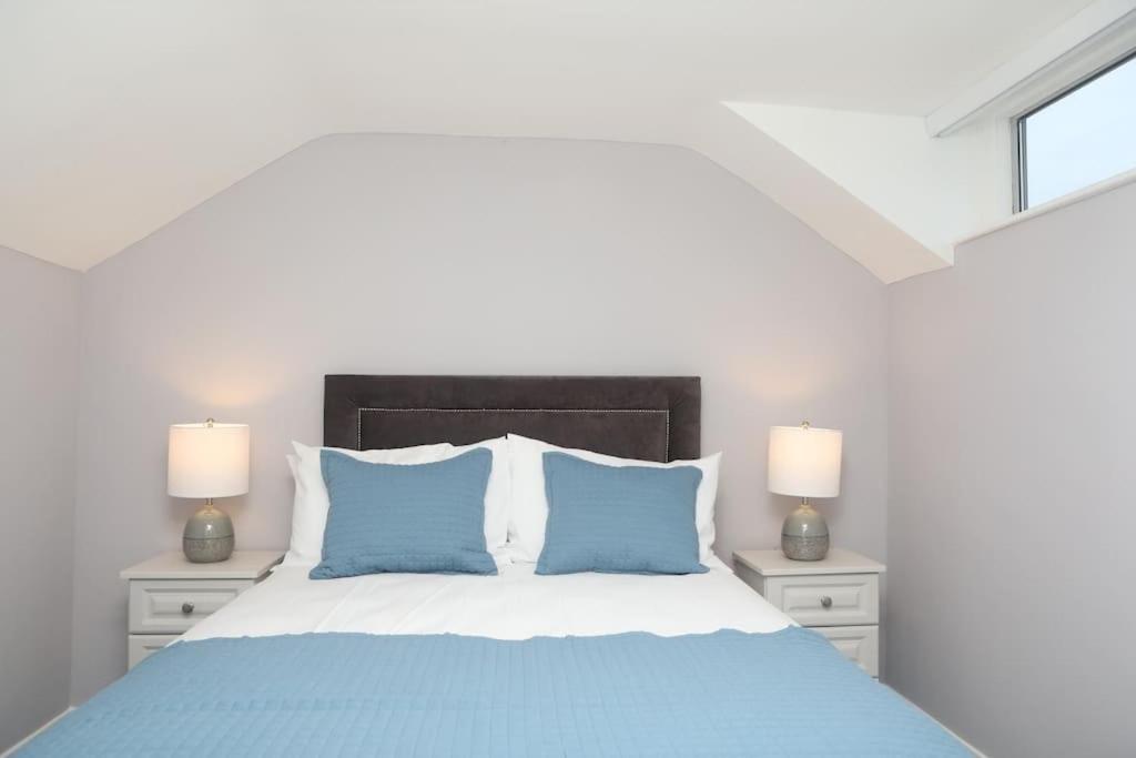 a bedroom with a bed with blue pillows and two lamps at Dillon house, Ballina in Ballina