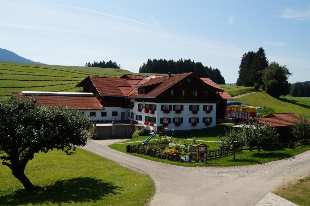 a large house on a hill with a road at Ferienhof Eger in Immenstadt im Allgäu