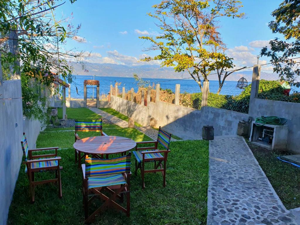 una mesa y sillas en un patio con vistas al agua en Villa Don Pedro - Casa de descanso en San Pedro La Laguna
