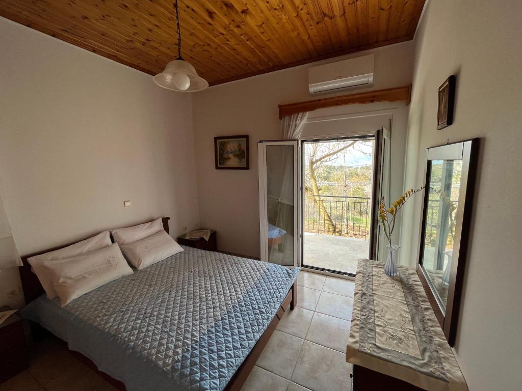 a bedroom with a bed and a sliding glass door at Villa Lazaros in Aidoniá