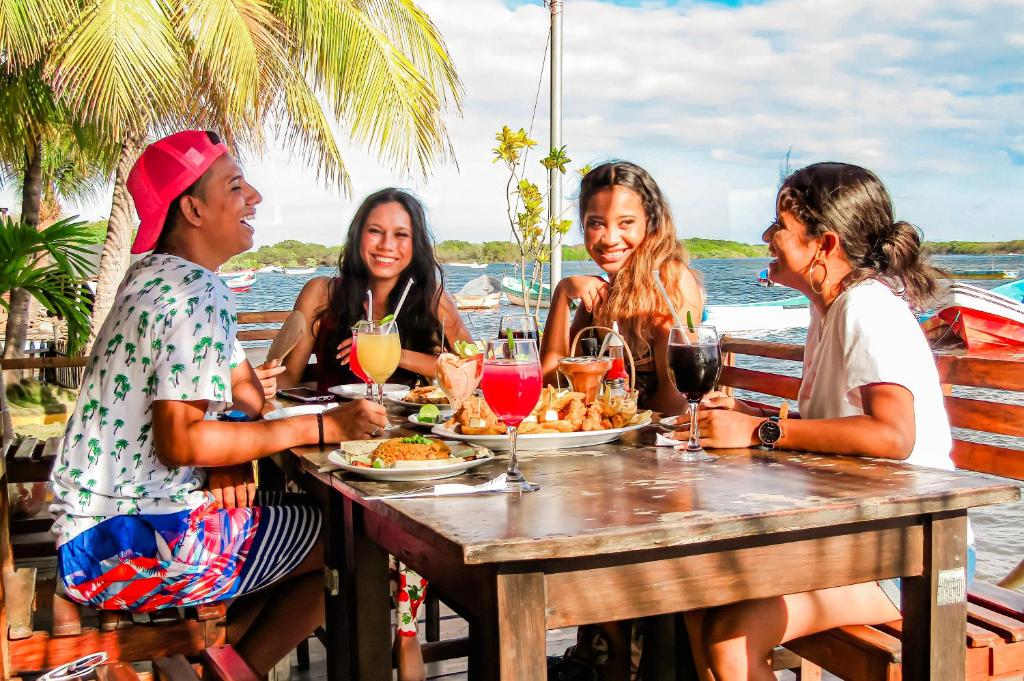 Un gruppo di donne sedute a tavola che mangiano cibo di Hotel Restaurante Spa La Barca de Oro a Las Peñitas