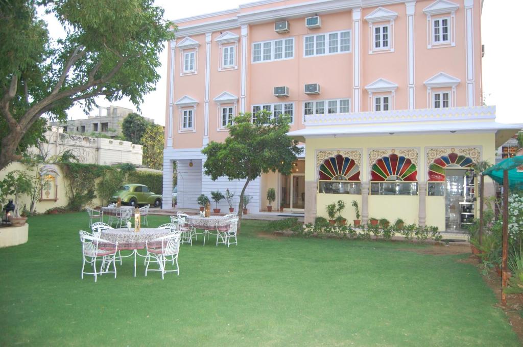a pink building with tables and chairs in front of it at Anuraag Villa in Jaipur