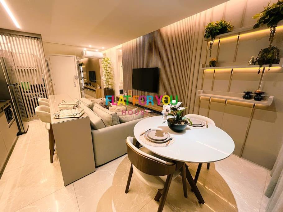 uma sala de estar com uma mesa e um sofá em #1306T# Apartamento 1Q Luxuoso, Metropolitan Sidney Jd. Goiás em Goiânia