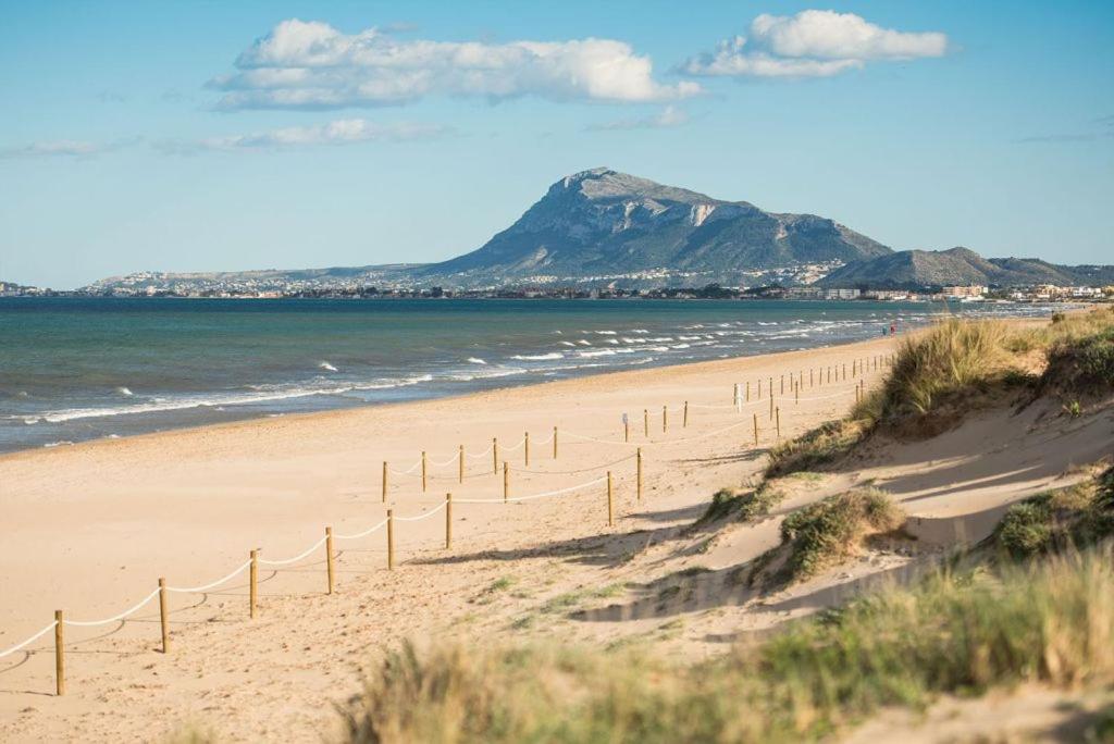a sandy beach with a mountain in the background at Apartamento MariaLuisa in Oliva