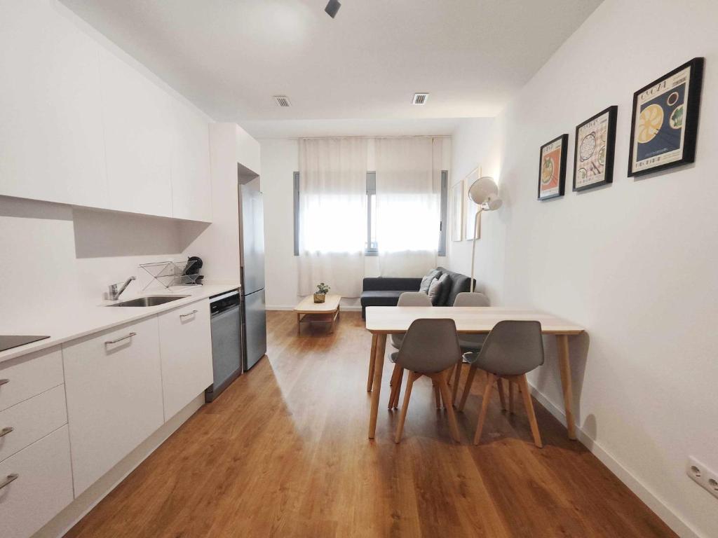 kuchnia i salon ze stołem i krzesłami w obiekcie Mazi Apartments Loft w mieście Mataró