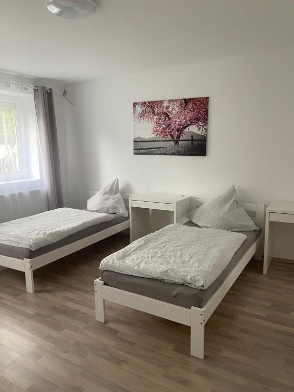 a bedroom with two beds and a painting on the wall at Unterkunft für Arbeiter und Monteure in Fürstenfeldbruck