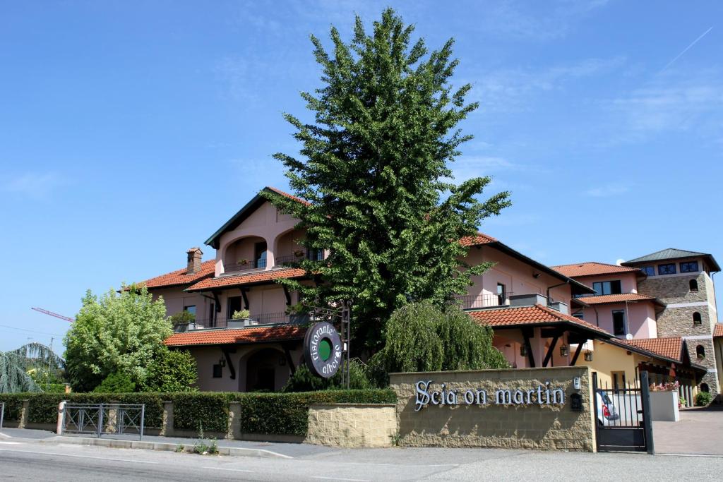 a building with a pine tree in front of it at Scia' On Martin in Buscate