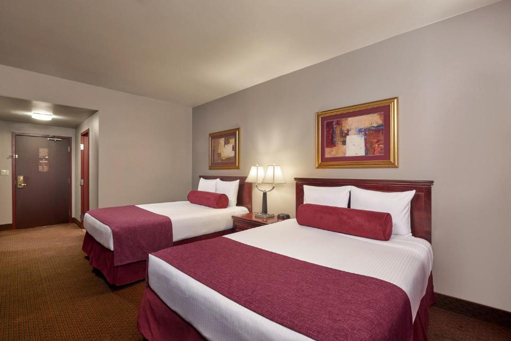 a hotel room with two beds with red and white sheets at DOWNTOWN LAS VEGAS Beautiful Unit at 4 Queens Casino FREMONT in Las Vegas