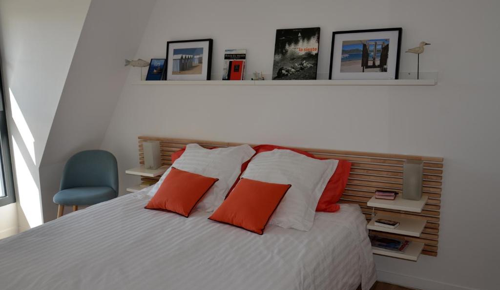 a bedroom with a white bed with red pillows at Le Beau Repaire 1 à 3 chambres étage indépendant in Angers