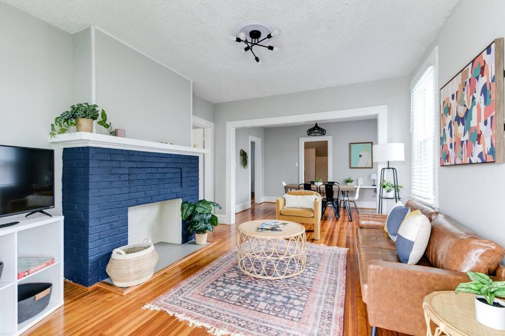 uma sala de estar com uma lareira de tijolos azuis em Private Boho Bungalow 10 Minutes to Downtown RVA! em Richmond