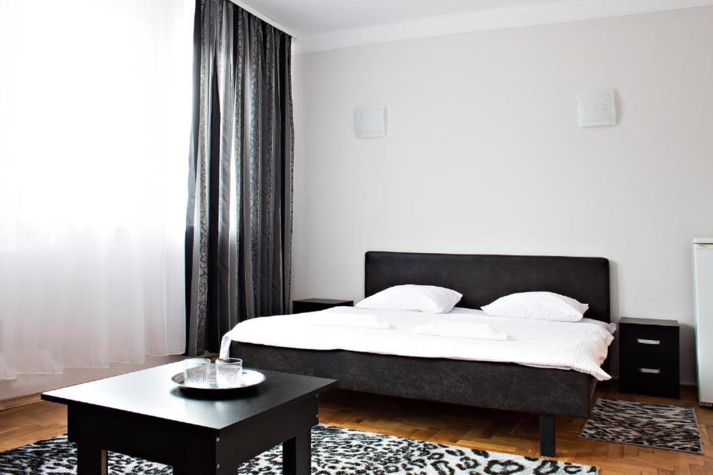 Hotel Sofiivka في Konopnitsa: غرفة نوم بسرير وطاولة قهوة