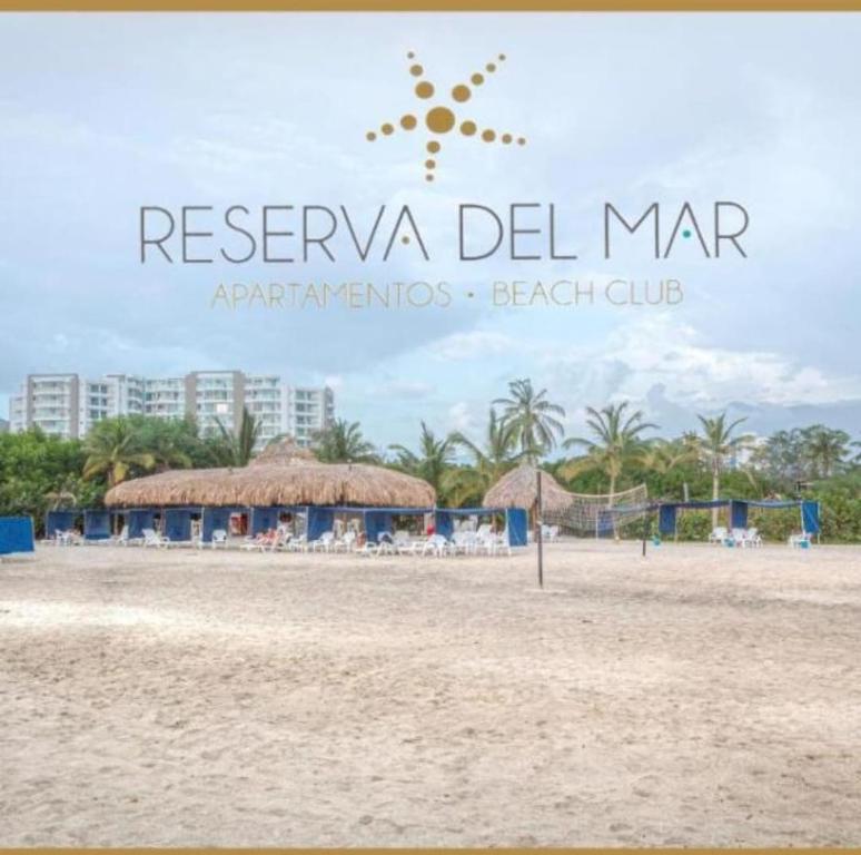 a sign on the beach with a beach club at Apartamento frente al mar en Reserva del Mar apto 1829 in Gaira