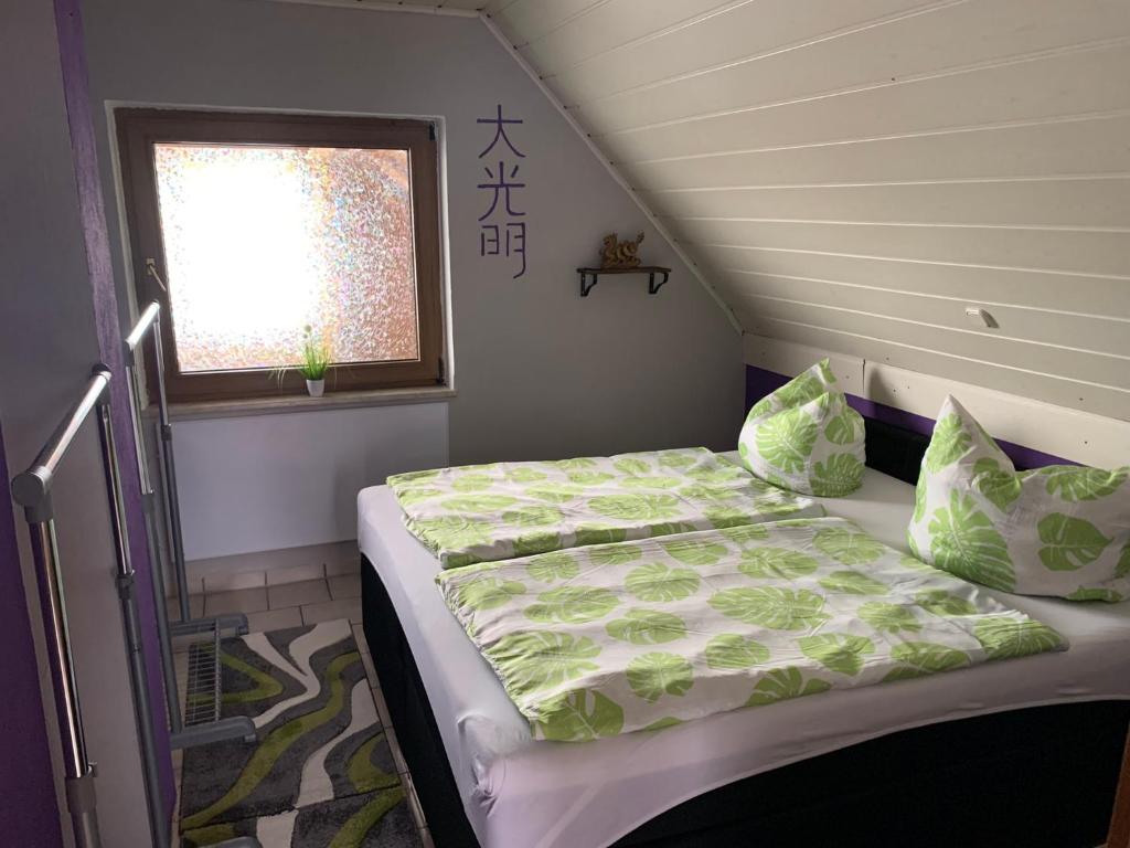 um pequeno quarto com uma cama e uma janela em Ferienwohnung/Monteurwohnung SZ-Reiki em Erbendorf